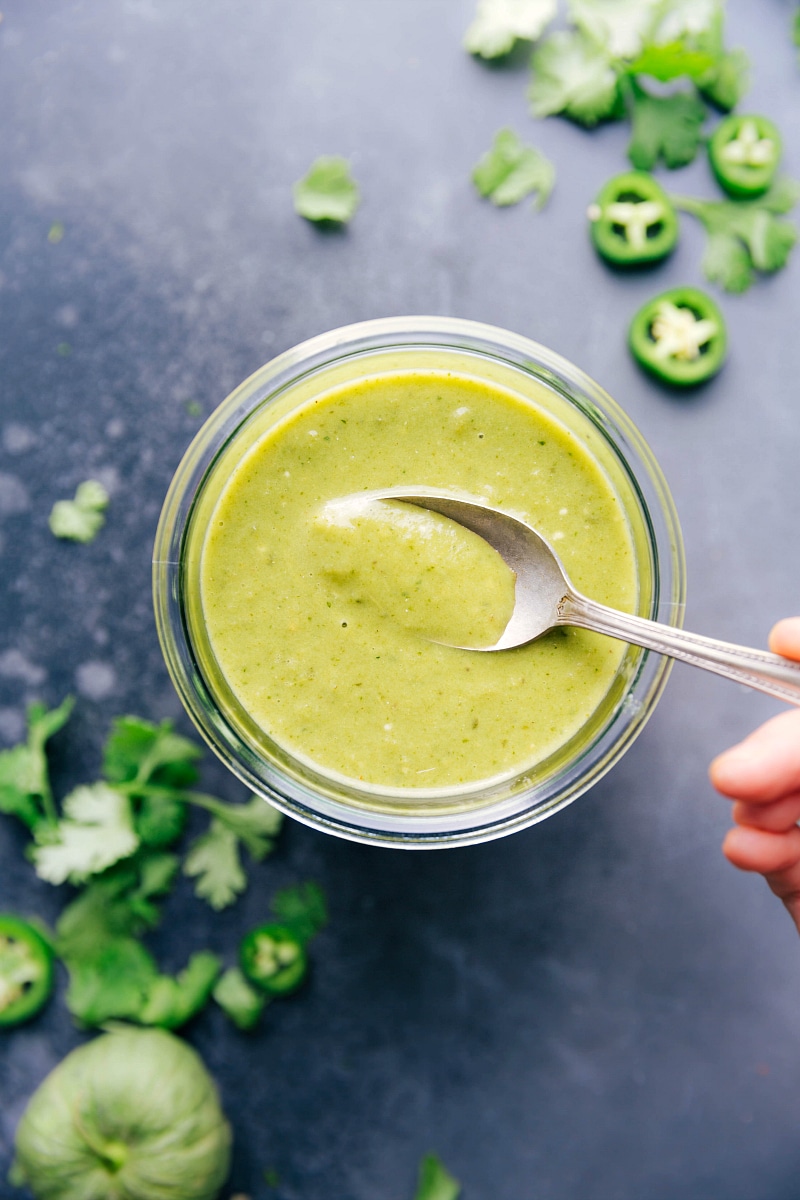 Green Enchilada Sauce has so much flavor that you'll never want to go back to the canned sauce again! This easy homemade enchilada sauce is made from a mixture of tomatillos, onion, peppers, and garlic. To add flavor and consistency, we throw in some well-loved seasonings, vegetable broth, and olive oil. Recipe via ChelseasMessyApron.com #enchiladas #greensauce #greenenchiladas #tomatillos #mexican #spicy #tacotuesday Green Enchilada Sauce in a jar.