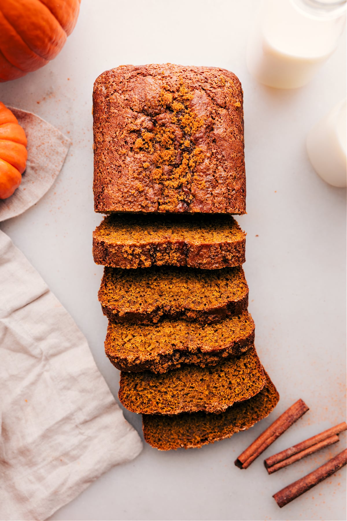 Overhead view of a loaf of pumpkin bread, with half sliced into individual pieces.