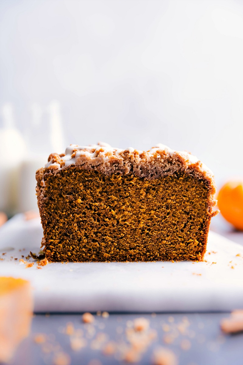 Image of a loaf of Pumpkin Bread With Streusel Topping with a slice out of it.