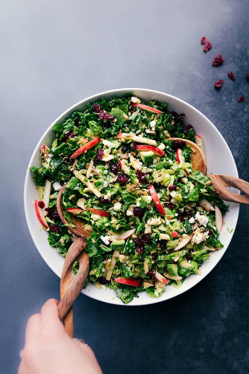 Overhead image of the Brussels Sprout Salad in a bowl being mixed together.