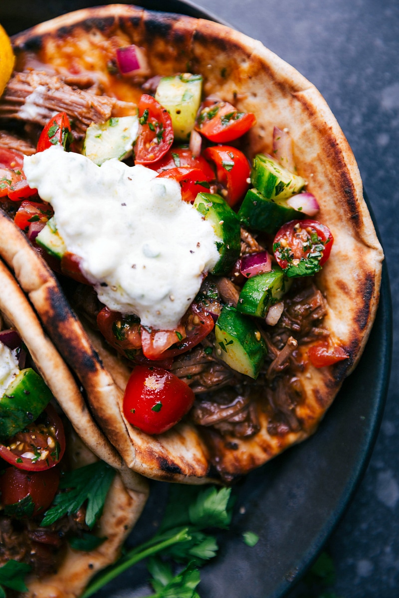 View of the folded Beef Gyro, showing the tzatziki sauce, salad and meat.