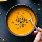 Carrot Soup in a bowl garnished with pepita seeds, a healthy and delicious meal.