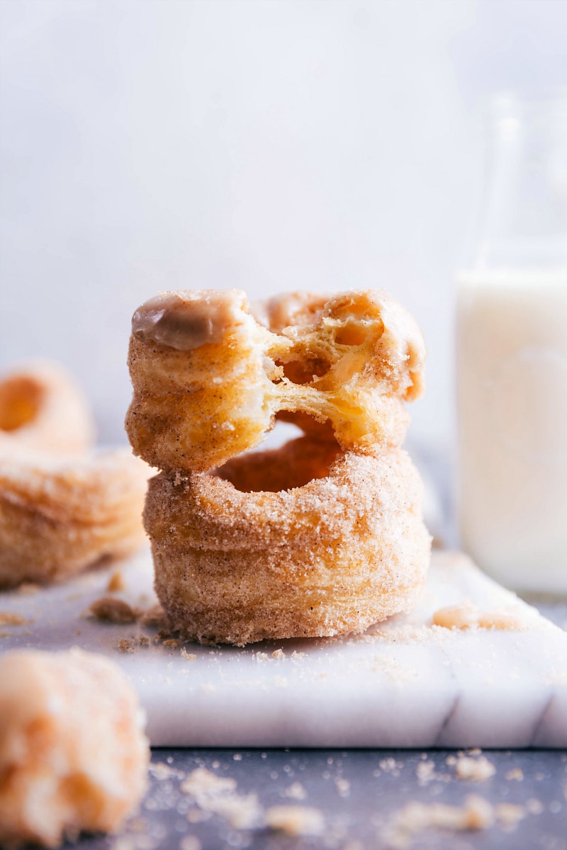 Closeup view of two Cronuts. One has a bite taken out of it.