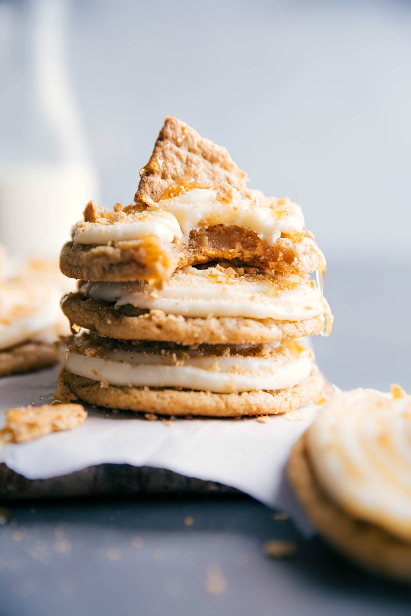 View of several Frosted Honey Graham Cookies stacked up, with a bite taken from the top one.