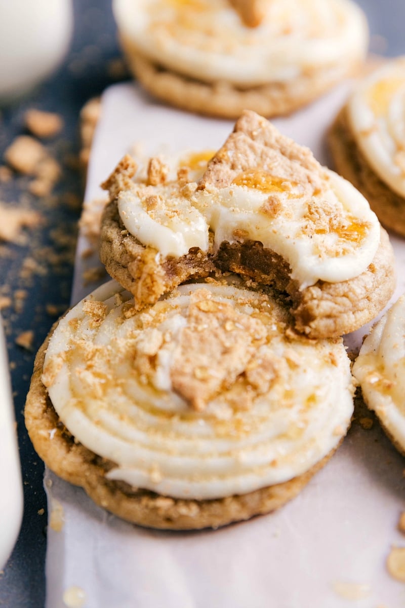 View of several Frosten Honey Graham Cookies, one of them with a bite take out of it.