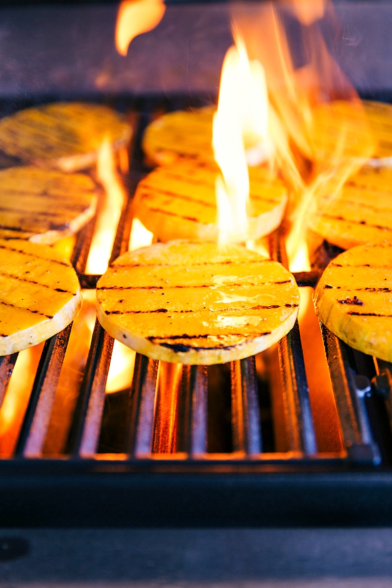 Image of the fire of the grill coming up on the butternut squash slices