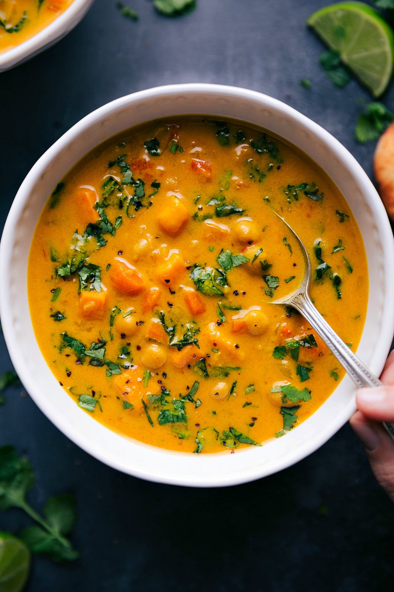 Overhead view of the sweet potato coconut curry soup with a spoon in it.