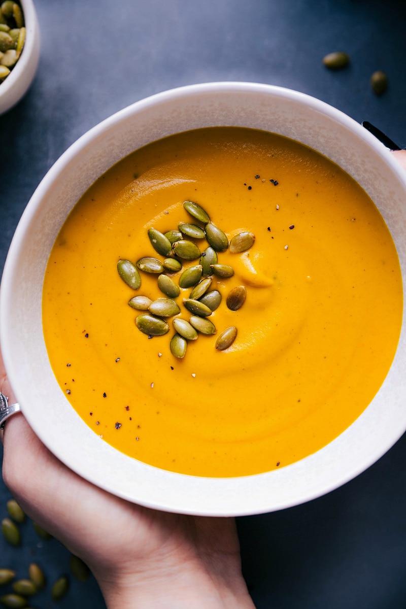 Overhead view of a bowl of Sweet Potato Soup, sprinkled with pepitas.