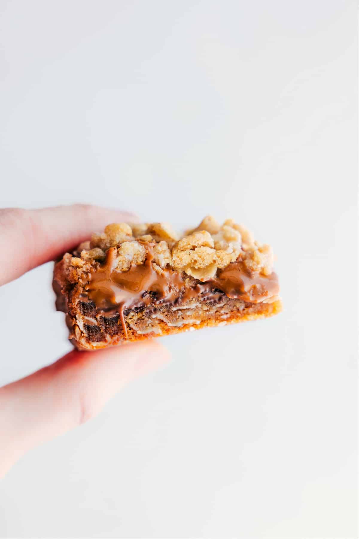 A cookie butter bar being held up showing the gooey and delicious center.