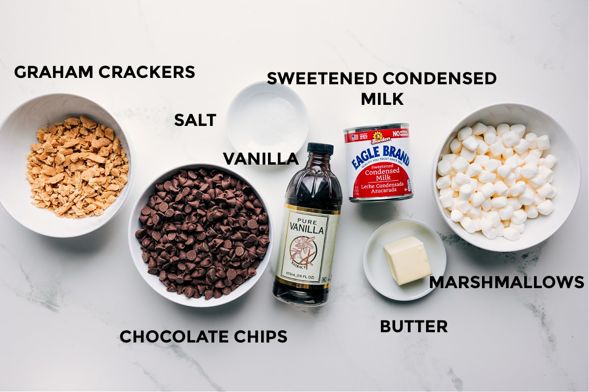 Ingredients In S'mores Fudge All the ingredients in this recipe prepped out including the graham crackers, chocolate chips, salt, vanilla, sweetened condensed milk, butter, and marshmallows.