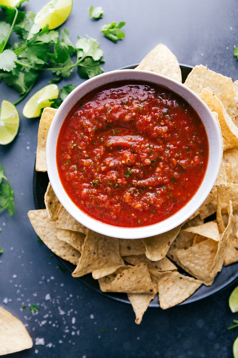A big bowl of delicious salsa, packed with vibrant flavors, paired with a pile of crispy chips ready for dipping.