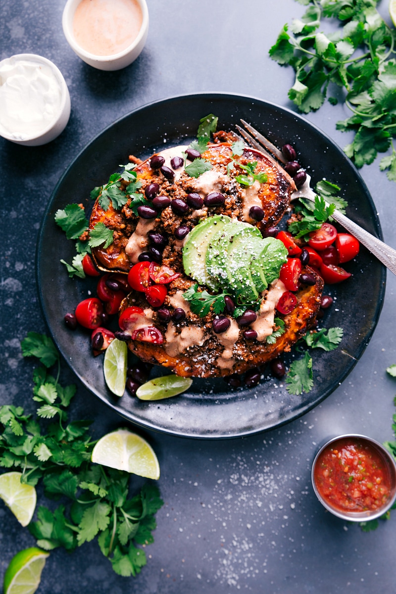 Overhead view of Taco-Stuffed Sweet Potatoes on a plate, with salsa on the side.