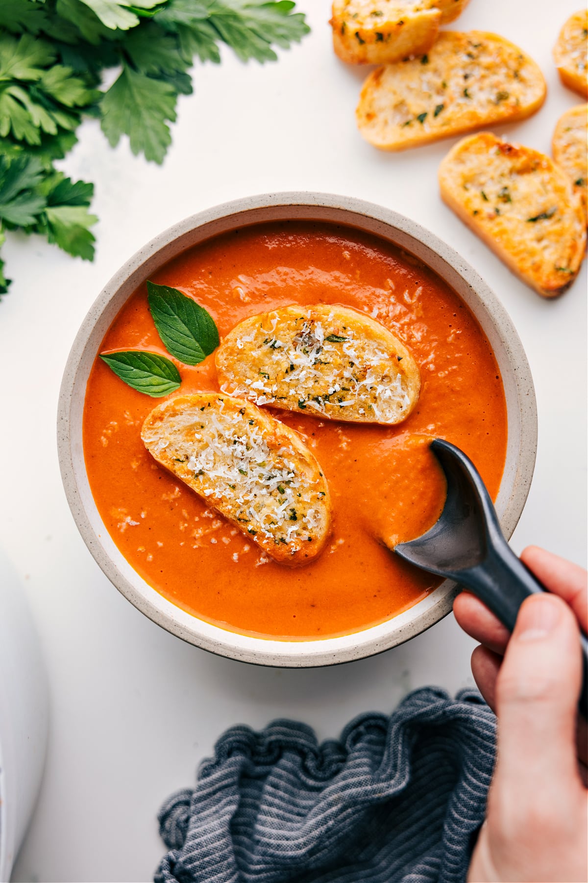 Bowl of easy tomato soup topped with a toasted baguette slice.