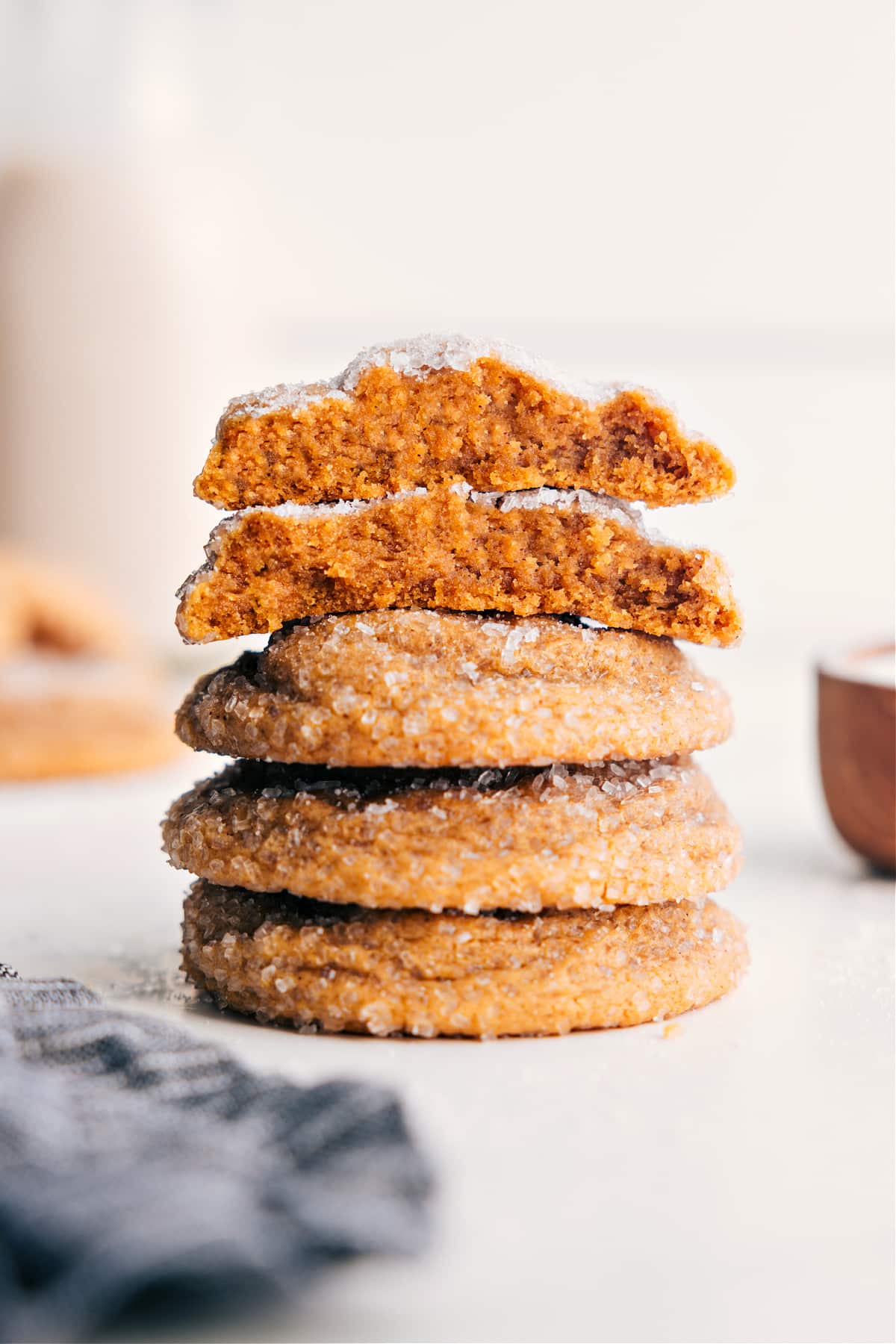 Tender And Sweet Molasses Cookies Molasses Cookie Recipe stacked on top of each other with the top one broken in half to show the chewy inside.