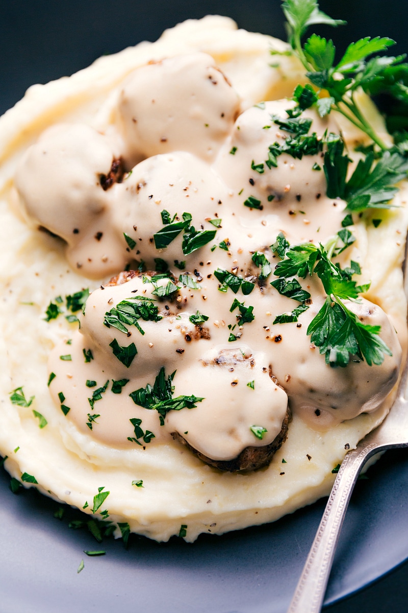 Image of Swedish Meatballs in sauce, over mashed potatoes and garnished with parsley.