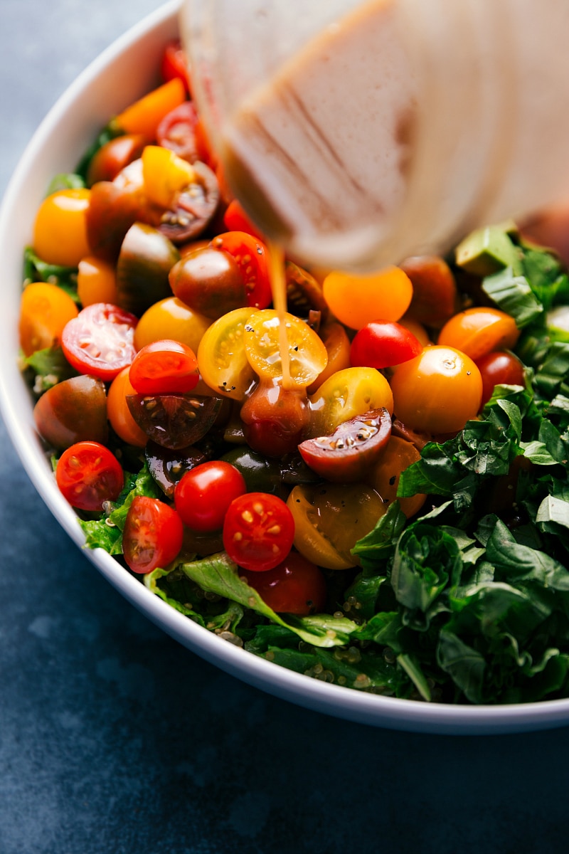 View of balsamic dressing being poured over Caprese Quinoa Salad.