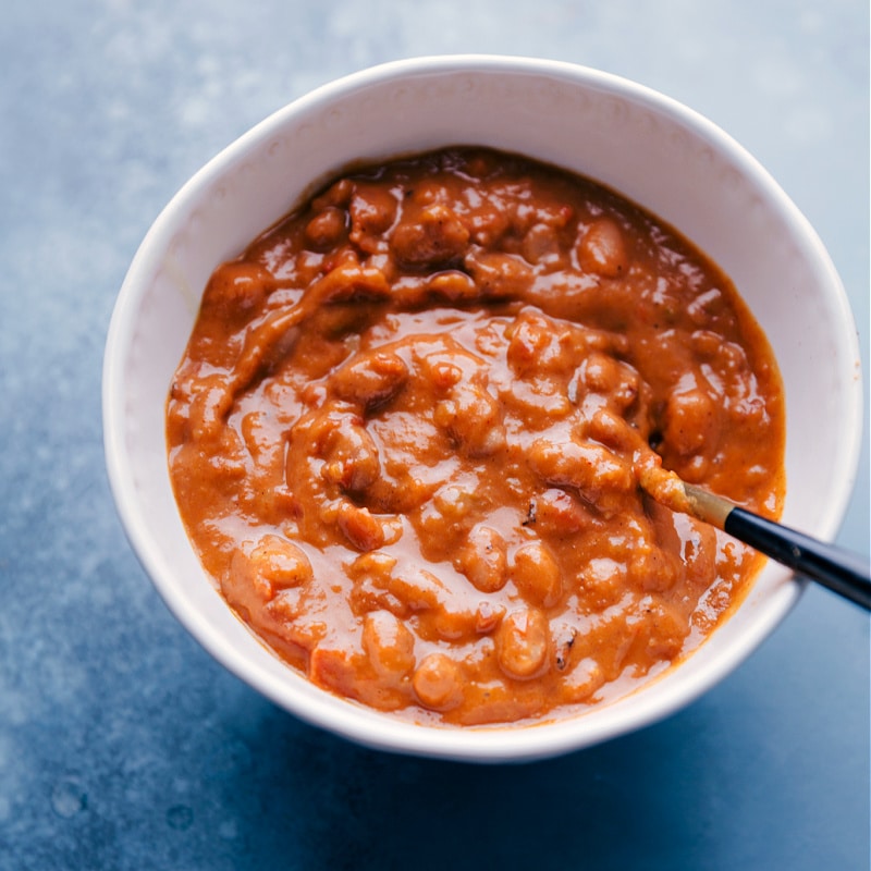 Overhead image of Pinto Beans in a bowl with a spoon in them.