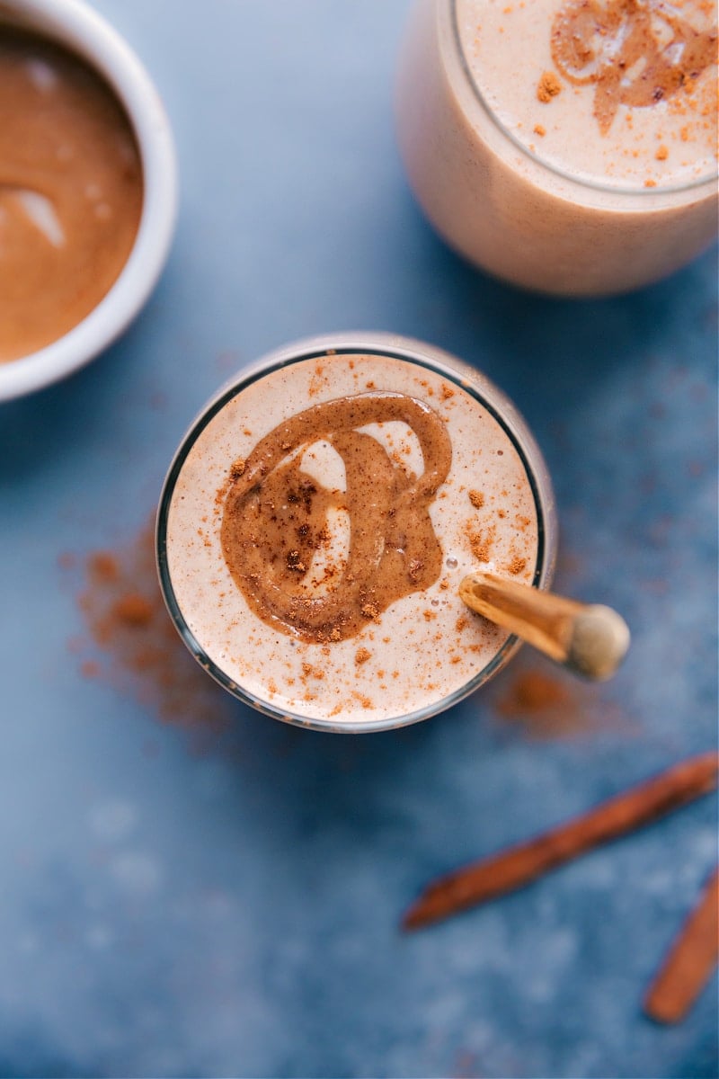 Stick with me here -- we're adding vegetables to a breakfast smoothie, but I promise you can't taste them! This Cauliflower Smoothie is sweet, filling, and tastes like a cinnamon roll in smoothie form. Recipe via chelseasmessyapron #healthy #best #quick #simple #blended #cauliflower #smoothie Overhead image of Cauliflower Smoothies garnished with cinnamon.
