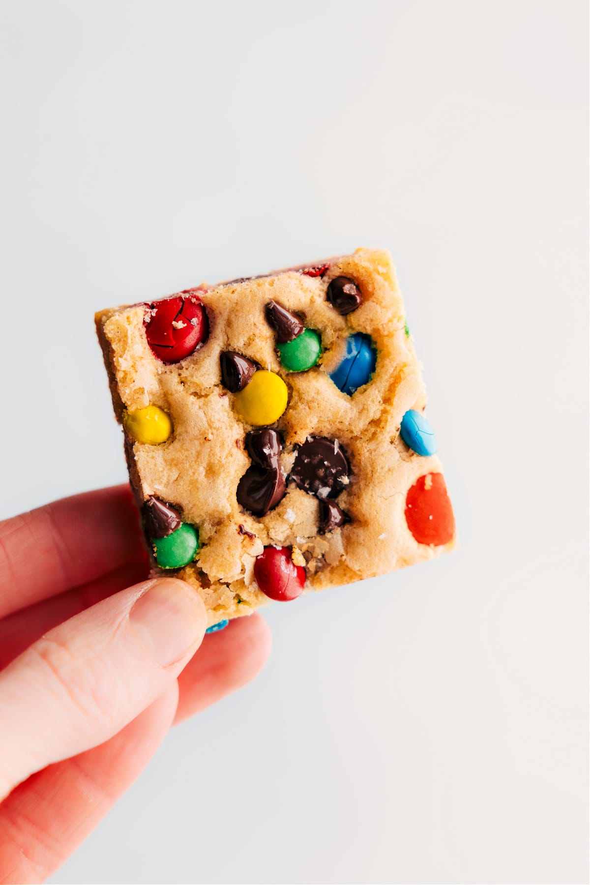 M&M Cookie Bars being held up.