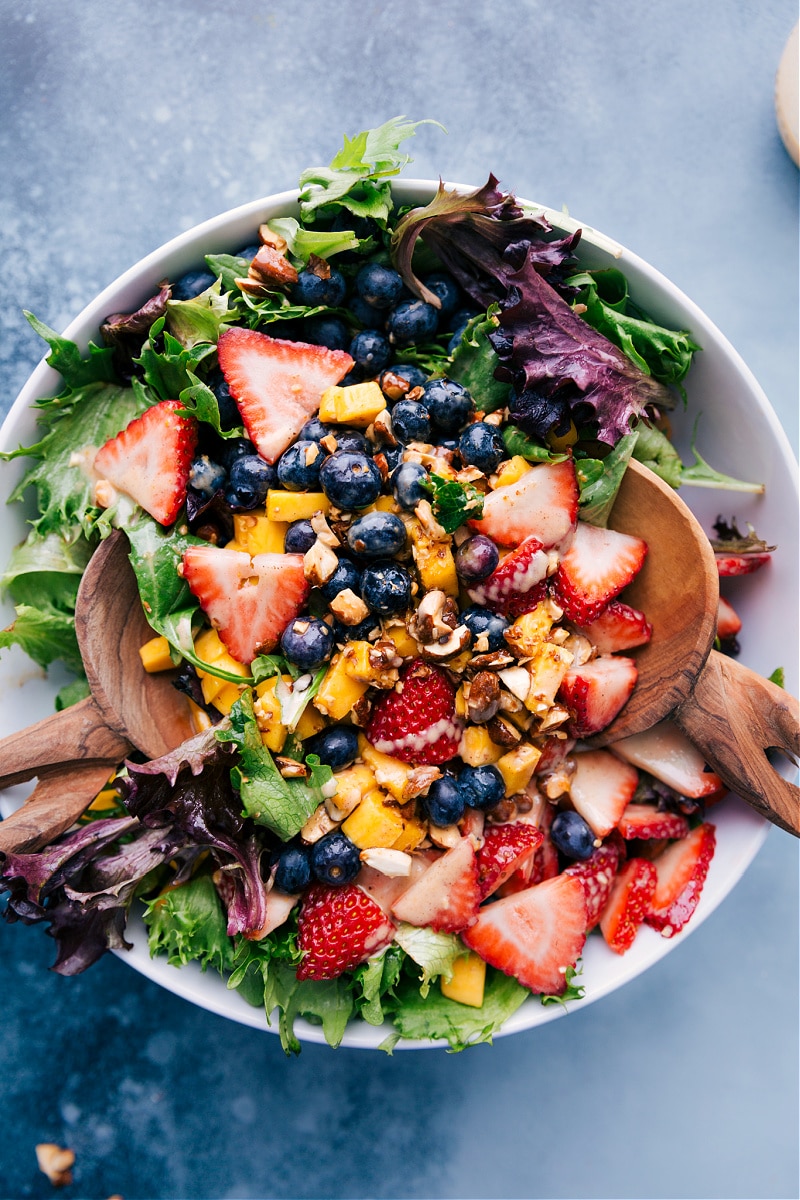 Overhead view of Mango salad with blueberries and strawberries.