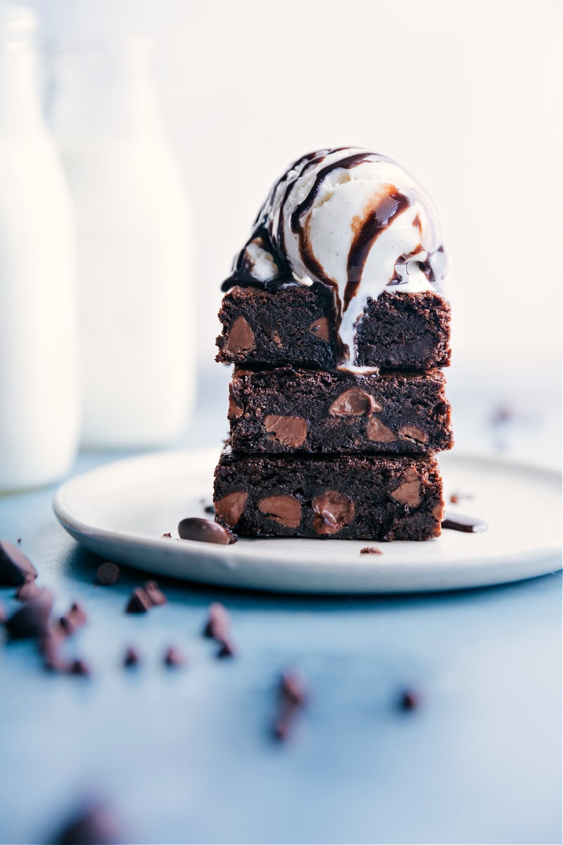 Brownies topped with ice cream and chocolate syrup