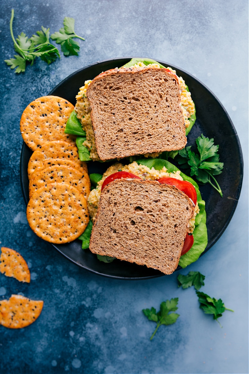 Overhead image of two of the vegetarian tuna sandwiches on a plate with crackers on the side