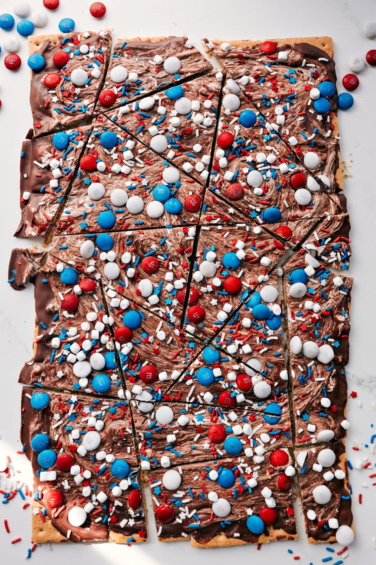 This 4th of July Bark Recipe is the perfect patriotic treat! This dessert is so tasty and with only four ingredients and no baking required, what's not to love?! Recipe via ChelseasMessyApron #festive #chocolate #whitechocolate #m&ms #sprinkles #dessert #treat #fourthofjuly #bark