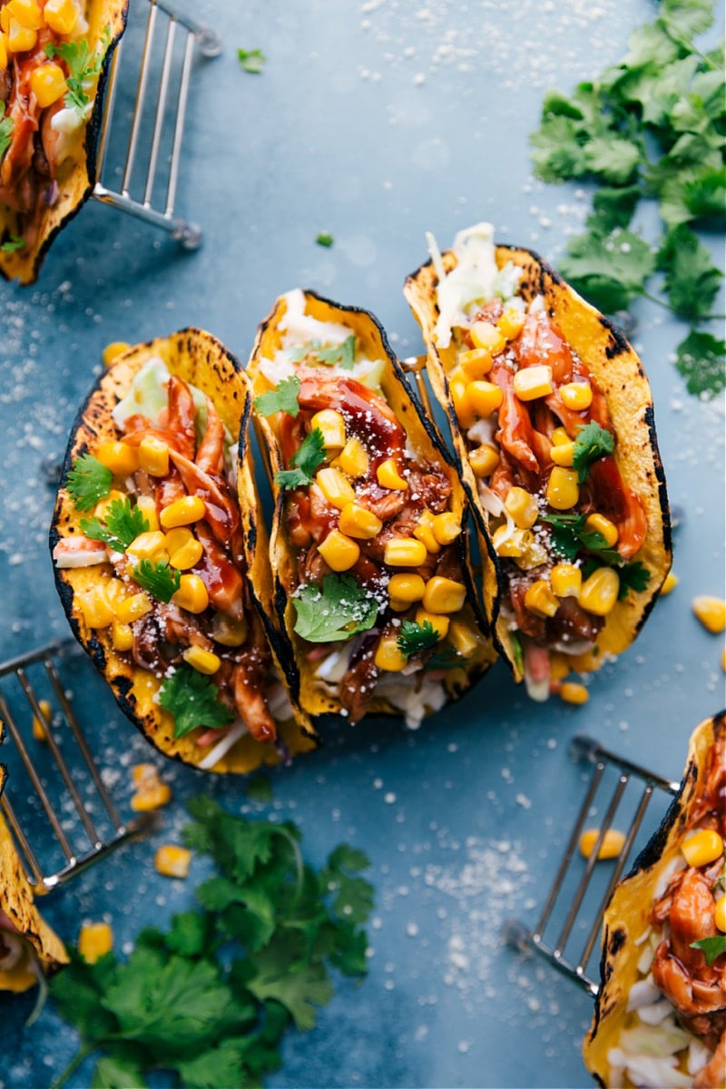 Super-quick BBQ Chicken Tacos with Coleslaw require minimal ingredients and pack a flavor punch! We toss packaged coleslaw with coleslaw dressing and load that up in a tortilla. Top with saucy BBQ chicken and fresh sweet corn and dinner's on the table! Recipe via ChelseasMessyApron #dinner #quick #easy #simple #best #corn #coleslaw #healthy #20minutes #bbq #chicken #tacos BBQ Chicken Tacos with Coleslaw