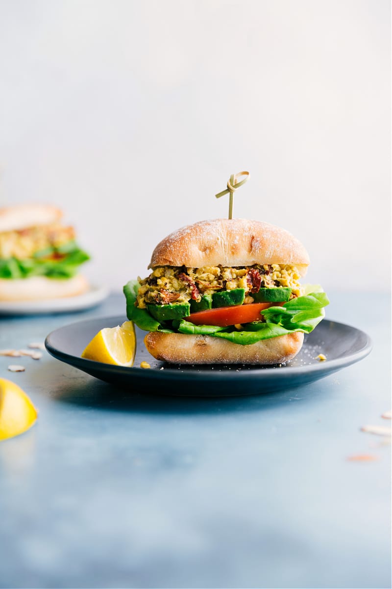 Pesto Chickpea Sandwiches are ready in a flash! Grab out a large bowl and mash up some chickpeas with store-bought basil pesto, sun-dried tomatoes, and almonds for a flavorful, hearty, and nutritious meal! Recipe via ChelseasMessyApron #dinner #lunch #quick #easy #simple #best #vegetarian #clean #cleaneating #avocado #pesto #chickpea #sandwich Pesto Chickpea Sandwich