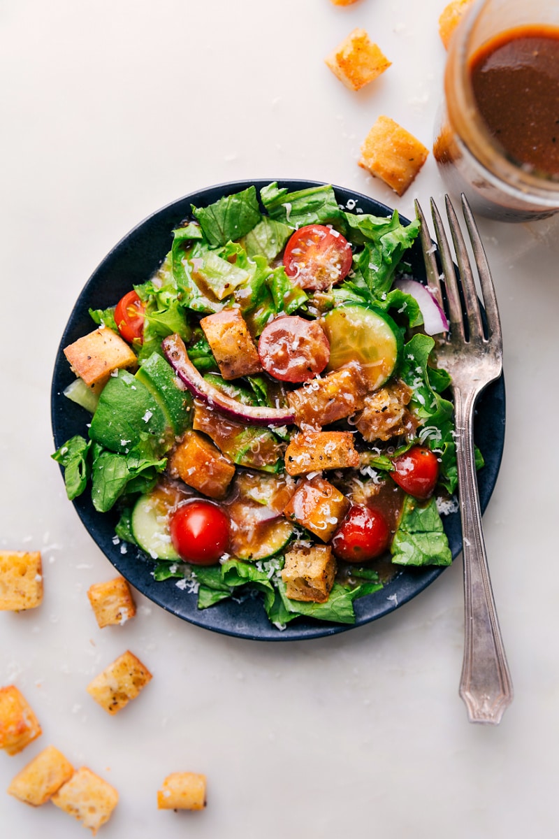 This simple Balsamic Vinaigrette takes mere minutes to whip together and no special kitchen appliances needed! This tangy vinaigrette has nicely balanced flavors and a great thickness -- the perfect topping for a simple side salad, garden salad, or topping on roasted vegetables! Recipe via ChelseasMessyApron #salad #saladdressing #clean #healthy #sidesalad #balsamic #vinaigrette Overhead image of the Balsamic Vinaigrette on a salad