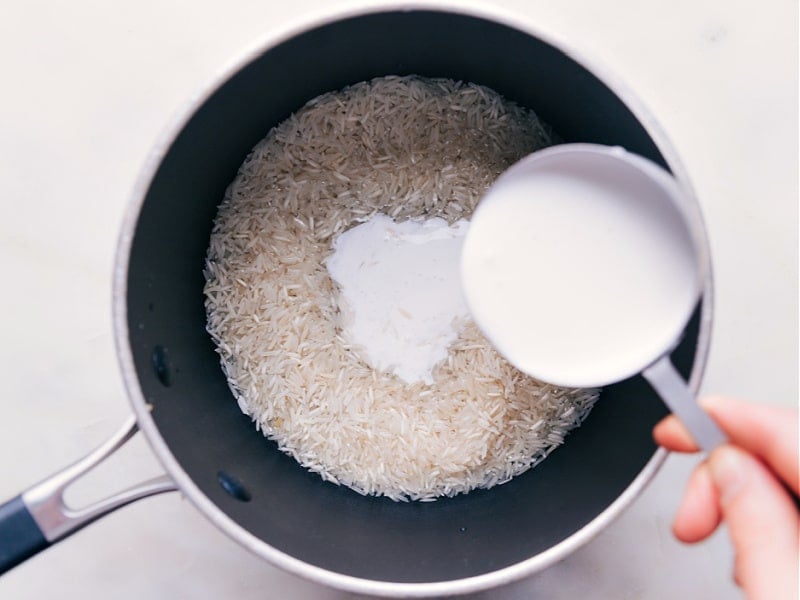 Pouring coconut milk into the pot.