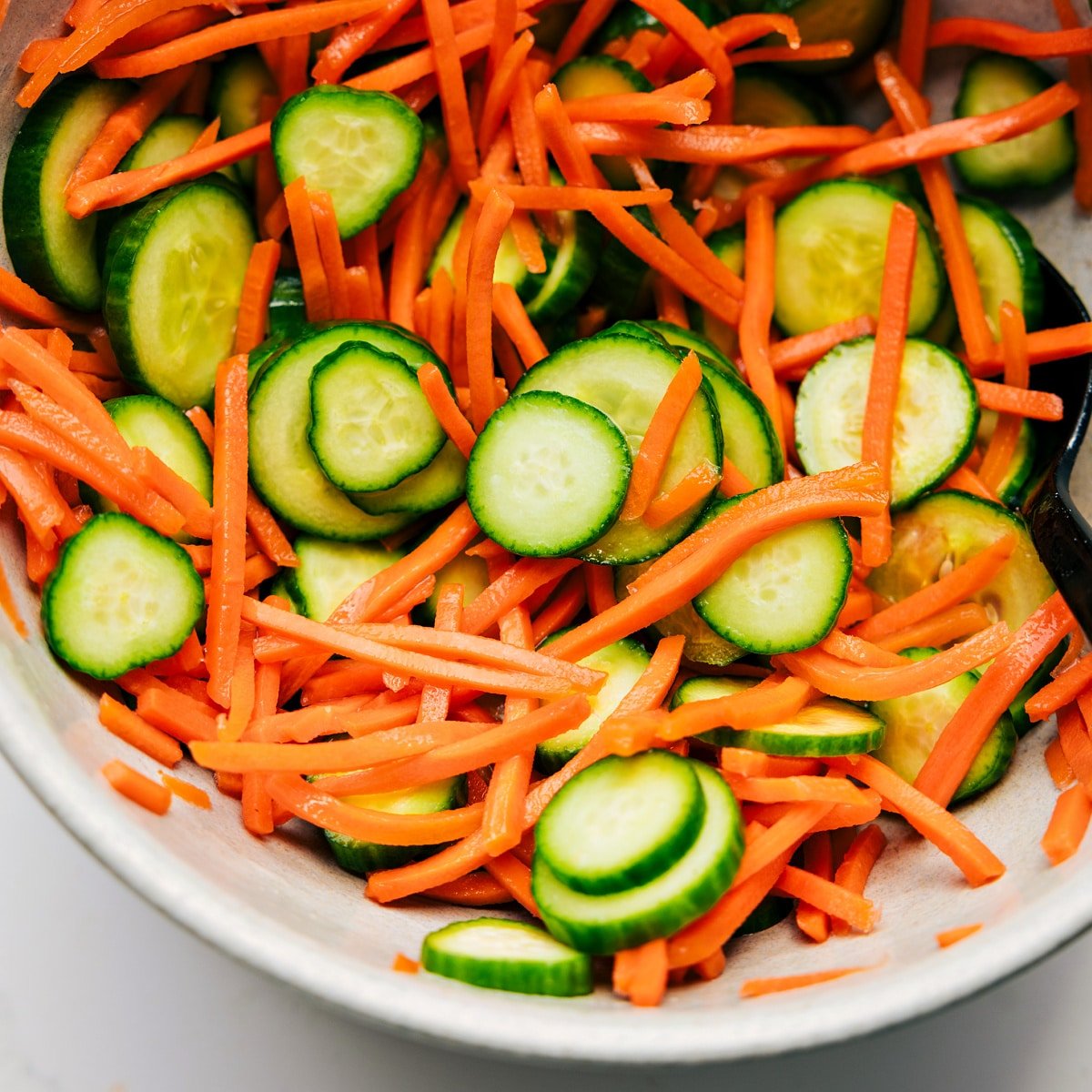 Quick cucumber and carrot salad mixed together in a bowl to serve with this Korean ground beef.