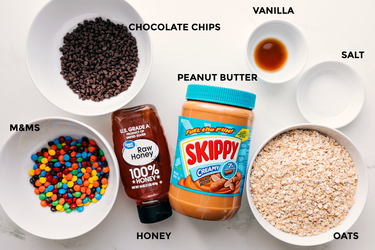 Ingredients In These Monster Energy Balls All the ingredients in this recipe prepped out for easy assembly including m&ms, chocolate chips, honey, peanut butter, vanilla, salt, and oats.