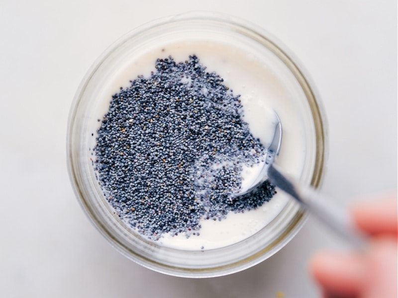 Image of the poppy seeds being added to the dressing