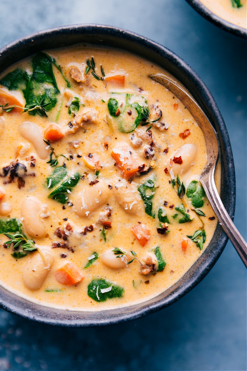 White Bean and Sausage Soup! The perfect comfort food! Recipe via ChelseasMessyApron #dinner #quick #easy #simple #spinach #carrots #bread #comfortfood #kidfriendly #familyfriendly #whitebean #soup Overhead image of a bowl of White Bean and Sausage Soup