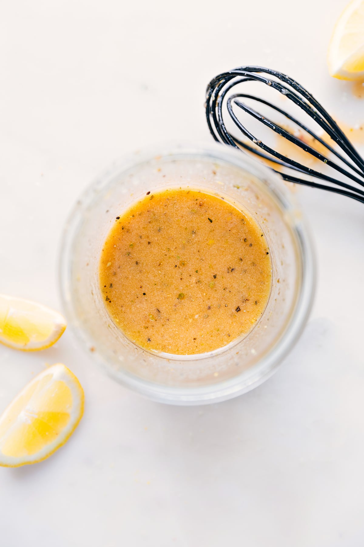 This zippy and tangy Lemon Vinaigrette is hands down my favorite dressing recipe! It's lively, tart with a touch of sweet, and robustly flavored. A must-have recipe in your cooking arsenal! Recipe via ChelseasMessyApron #dressing #best #quick #easy #lemonjuice #seasonings #salad #saladdressing #lemon #vinaigrette Lemon Vinaigrette whisked together in a mason jar.