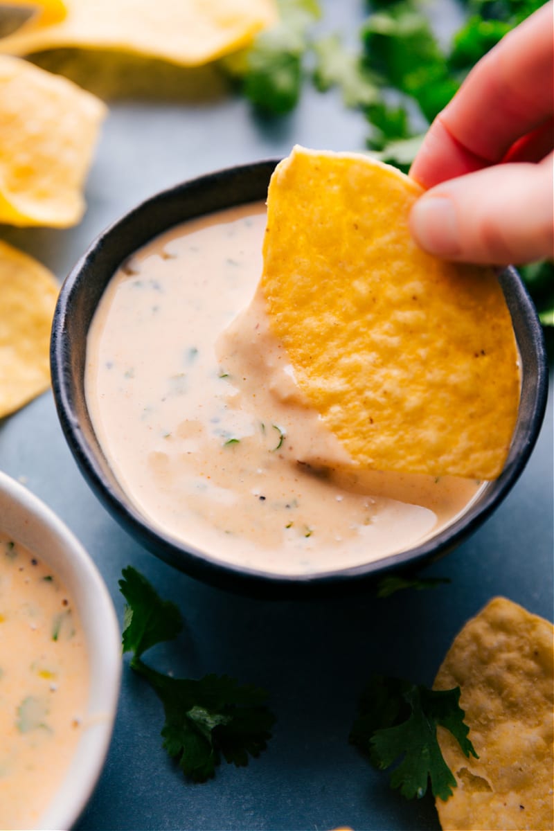 Overhead image of a chip being dipped in this Queso Dip Recipe