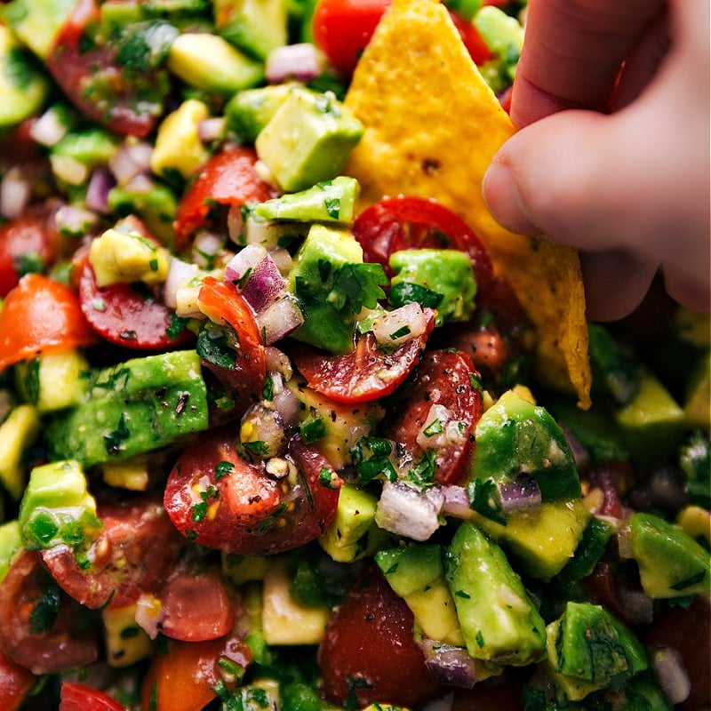 Close-up image of a chip being dipped into the Avocado Salsa