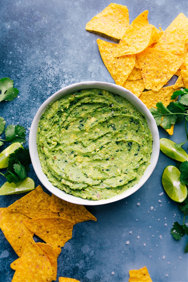 A large bowl of Guacamole with tortilla chips alongside.