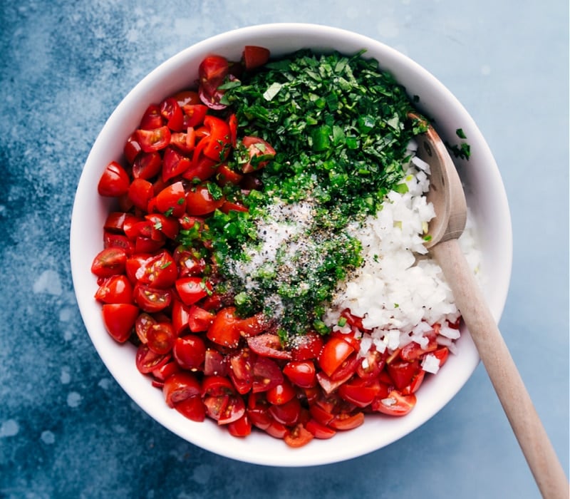 Process shot of the Pico de Gallo-- image of the salt and pepper being added