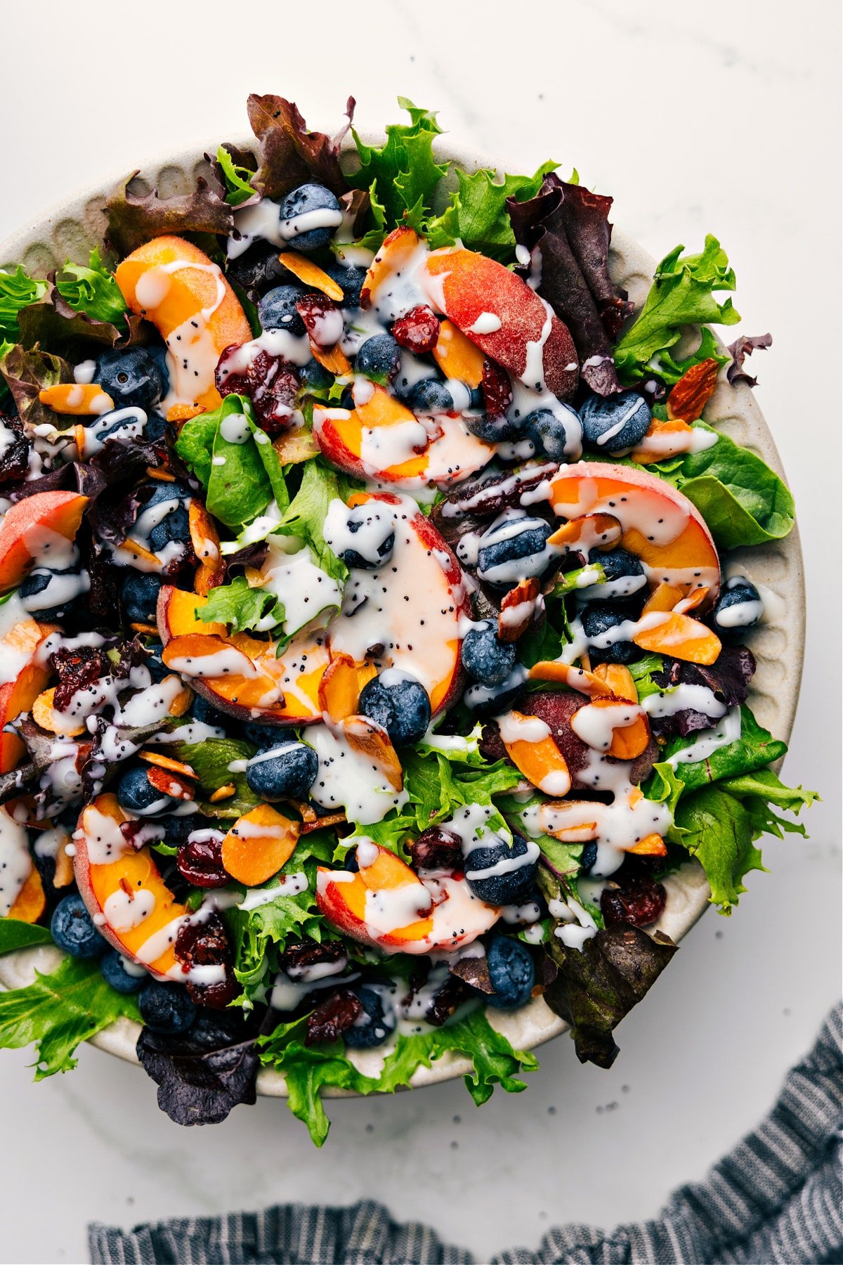 Simple And Delicious Poppyseed Dressing Recipe Bowl of peach and blueberry salad drizzled with this poppyseed dressing recipe.