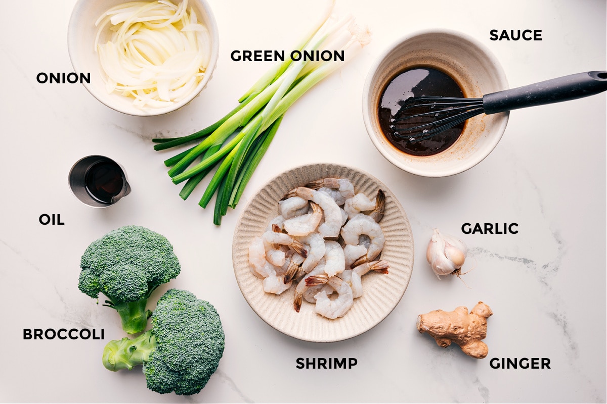 Ingredients In Honey Garlic Shrimp All the ingredients in this recipe prepped out for easy assembly including the onion, oil, broccoli, shrimp, green onion, sauce, garlic, and ginger.