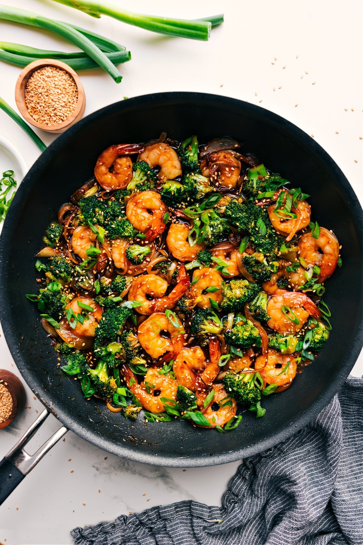 Fresh And Flavorful Honey Garlic Shrimp Honey Garlic Shrimp in the skillet with fresh green onions and sesame seeds on top.