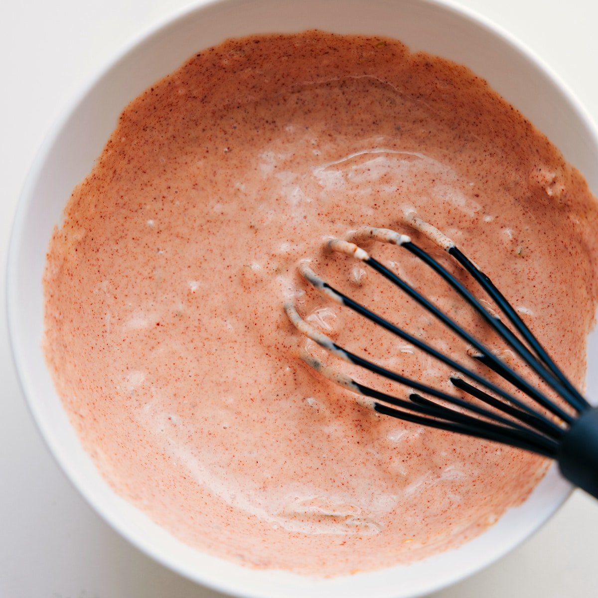 Burger sauce being whisked together in a bowl, ready to top the burger bowls.