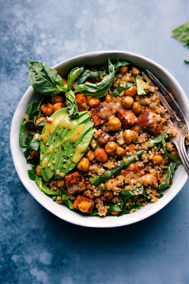 These Nourish Bowls are the best I've ever had! With hearty roasted veggies and chickpeas, vibrant greens, and the best hot honey mustard sauce -- you'll be in heaven! Recipe via ChelseasMessyApron #dinner #quick #easy #simple #best #fresh #familyfriendly #kidfriendly #cleaneating #wholefoods #nourish #bowls Overhead image of a Nourish Bowl
