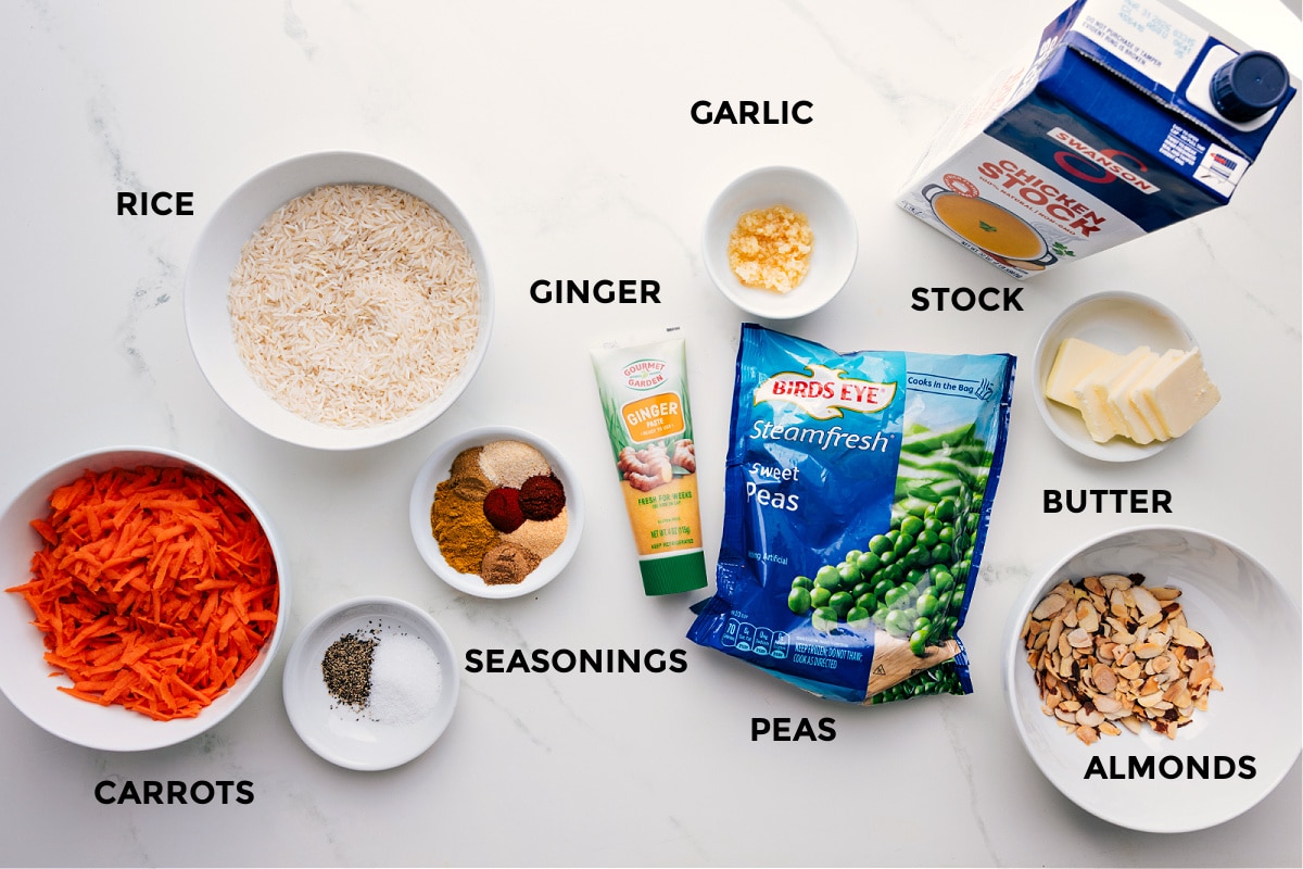Ingredients Being Added To The Pan For This Curry Rice All the ingredients in this recipe prepped out for easy assembly including the carrots, rice, seasonings, ginger, garlic, peas, stock, butter, and almonds.