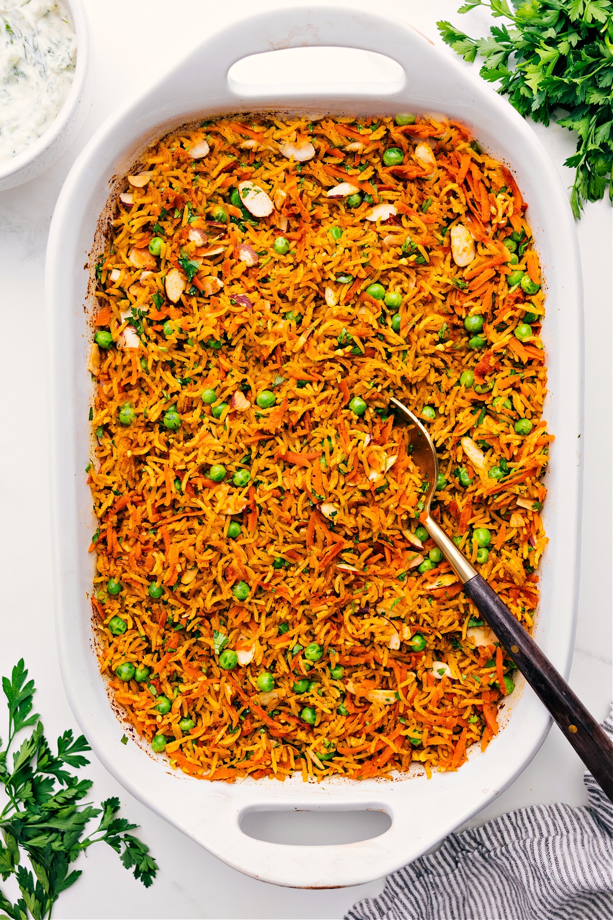 Mind Blowing Easy One Pan Curry Rice Curry Rice in a baking dish with a spoon serving a portion.
