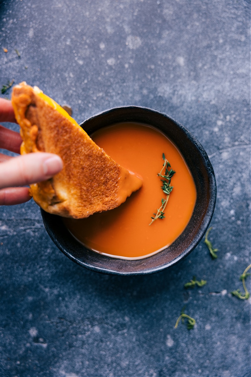 Overhead image of the sandwich being dipped in tomato soup