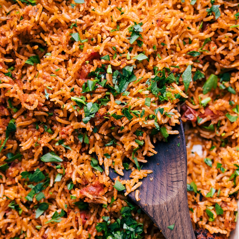 Mexican Rice being scooped with a wooden spoon