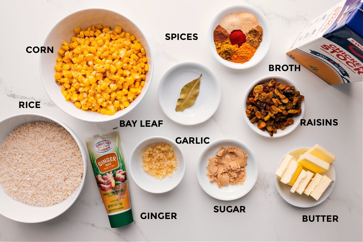 Ingredients In Yellow Rice Recipe All the ingredients in this recipe prepped out for easy assembly including the rice, corn, ginger, bay leaf, garlic, sugar, butter, raisins, broth, and spices.